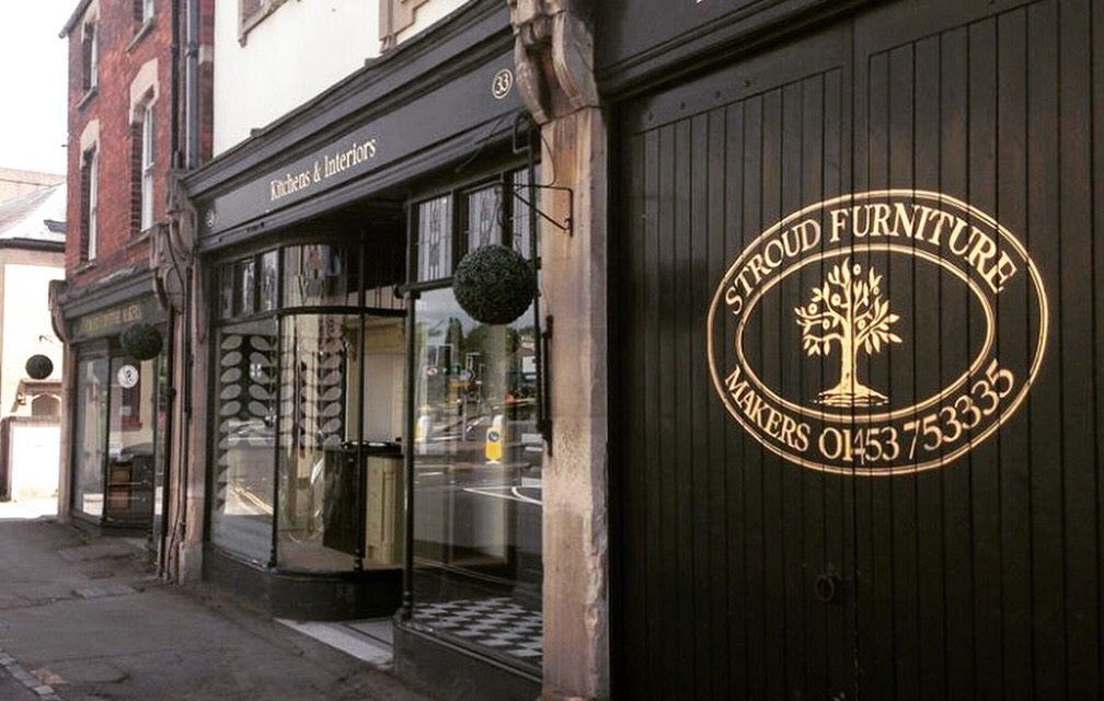 The Stroud Furniture Makers shopfront on Westward Road, black timber doors with the gilt tree logo and Kitchens and Interiors fascia